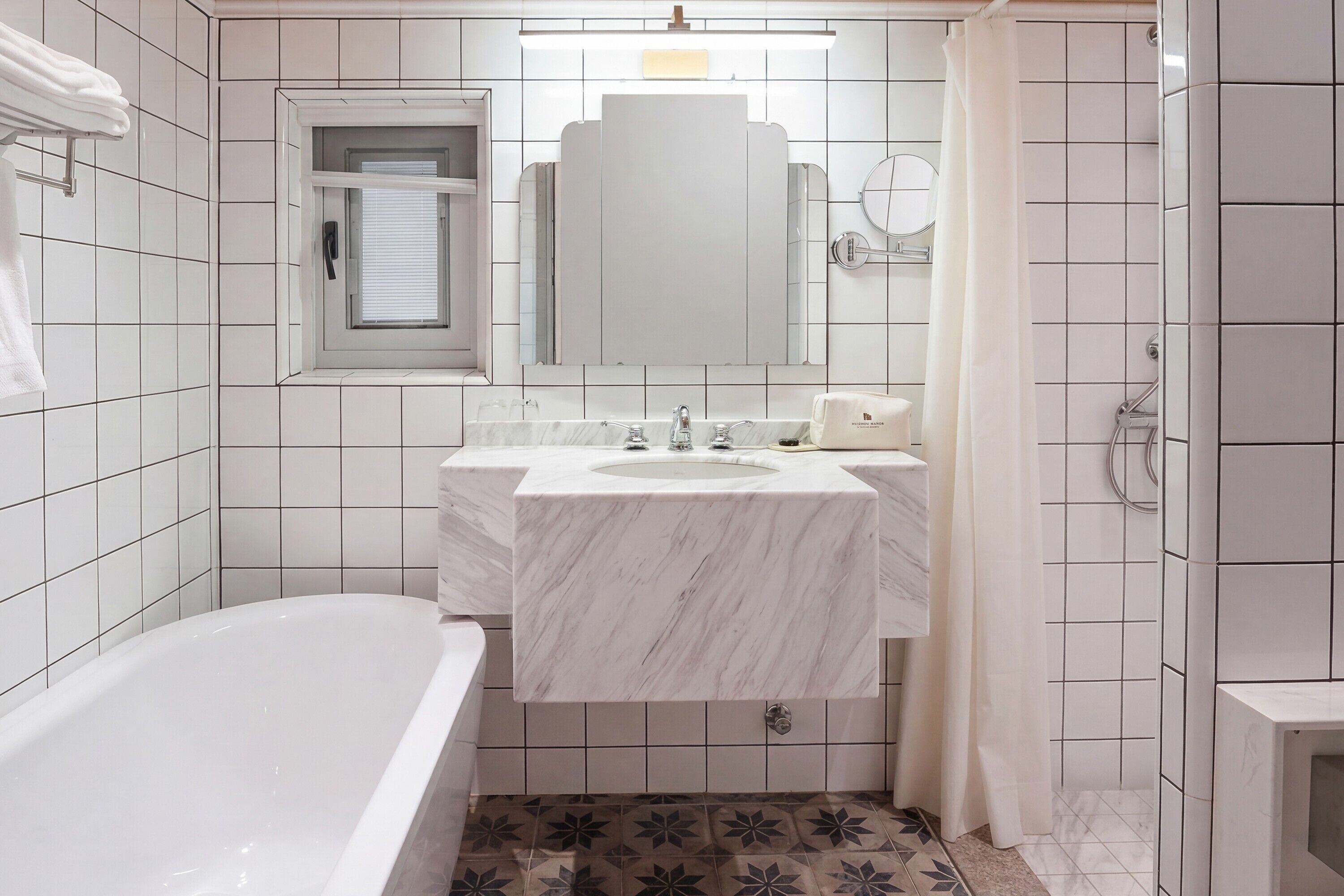 Une salle de bain avec une baignoire, un lavabo avec un miroir et un espace douche.