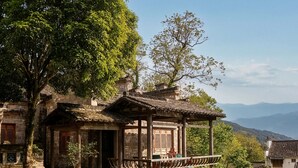 A traditional building with a wooden structure, a stone pathway, and a calm water body.