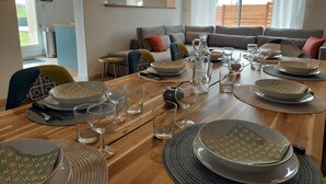 A dining area with a wooden table set for a meal, surrounded by chairs with patterned cushions. - Le colibri - Country house with private pool (Chambourg-sur-Indre)