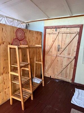 Una stanza in legno con una scaffalatura a scaletta in legno e una porta in legno.