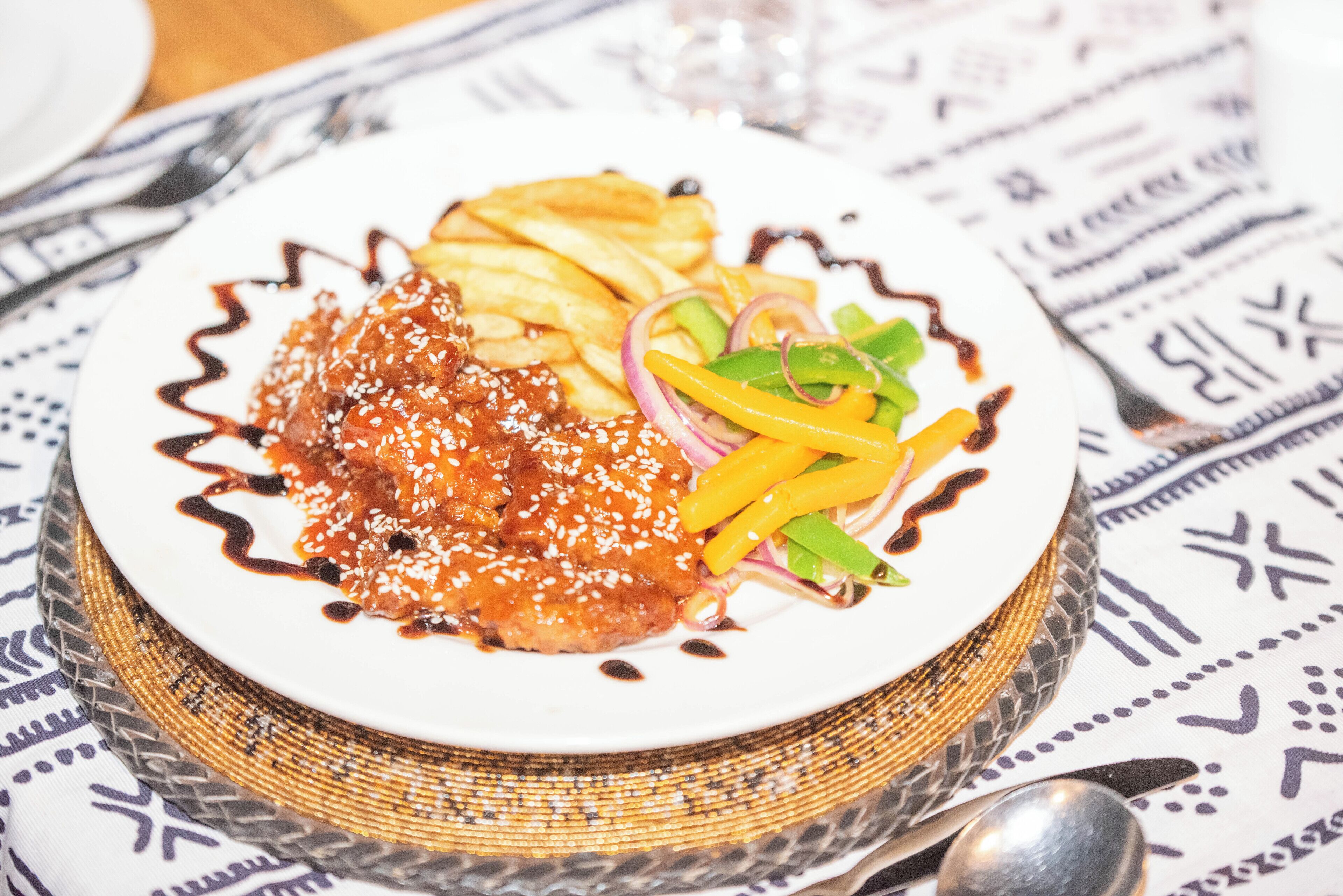 A plate of food with a patterned tablecloth.
