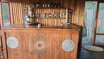 Una barra de madera con un diseño circular, botellas y ambiente rústico.