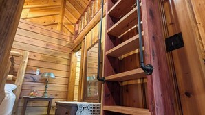 A wooden interior with a loft bed, a ladder, a desk, and a dresser. - Luxury Craftsman 1-bedroom cabin in SERENE beauty with AC, high end kitchen/bath (Ava)