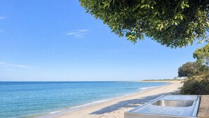 Une plage avec une structure en bois et un évier en métal.