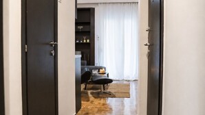 A hallway with a dark floor, a ceiling fan, and a dining area with a table and chairs. - D-Suites - Aristotelous Square Superior Apartment, Thessaloniki Centre (Thessaloniki)