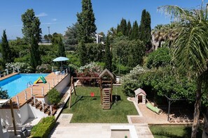 Ein Garten mit Swimmingpool, einer Holzterrasse und einer kleinen Grünfläche.
