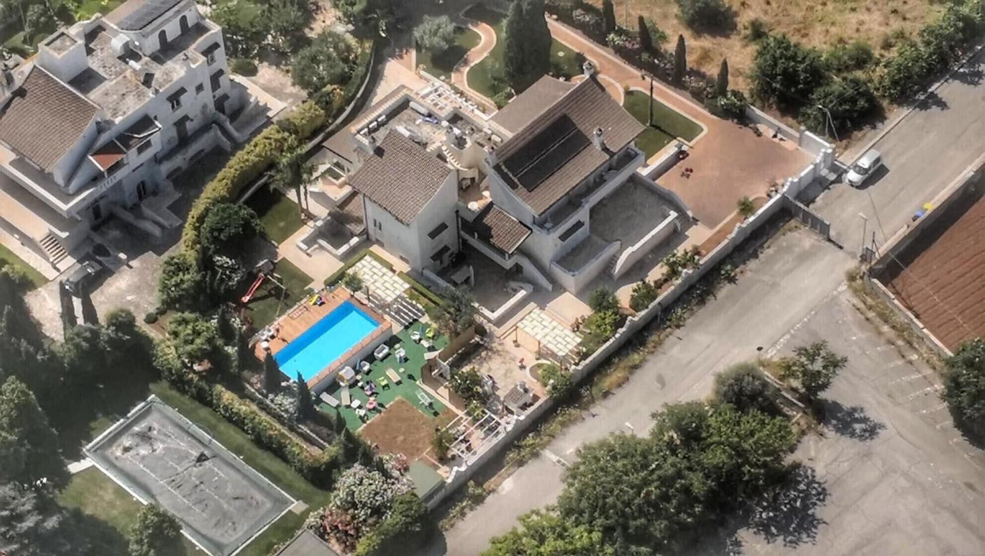 A residential area with multiple houses, a swimming pool, and a tennis court.