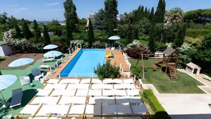 A pool area with lounge chairs, umbrellas, and a wooden deck. - Apartment 'Casa Torre Di Specchio with Pool' – Wi-Fi and Air Conditioning (Bari)