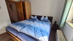 Une chambre à coucher avec un lit, une armoire en bois et un radiateur.