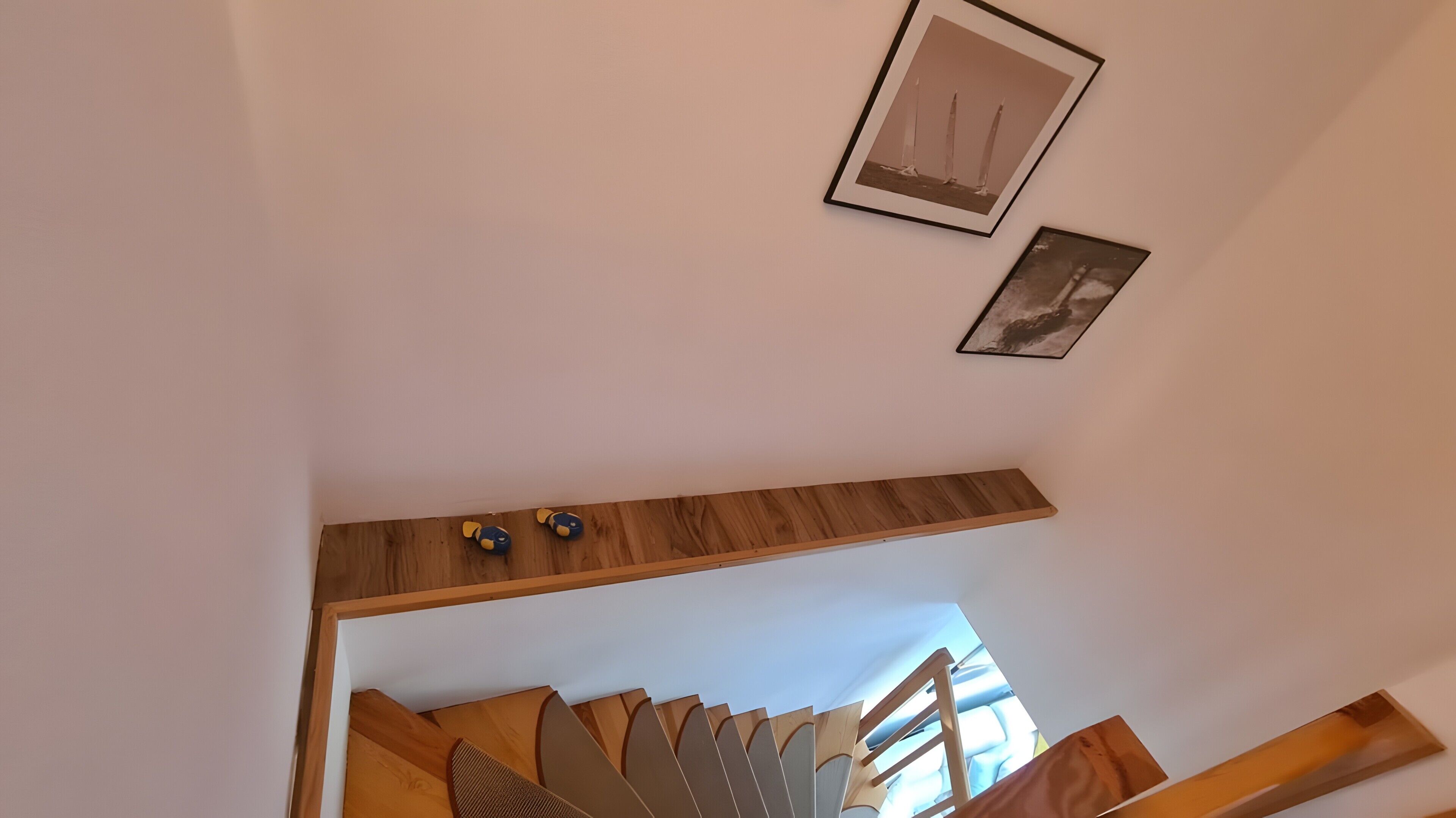 A staircase with a wooden handrail and a view of the sky through the top.