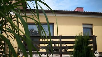 Ein modernes Gebäude mit großen Fenstern, einem Balkon und einem Zaun.