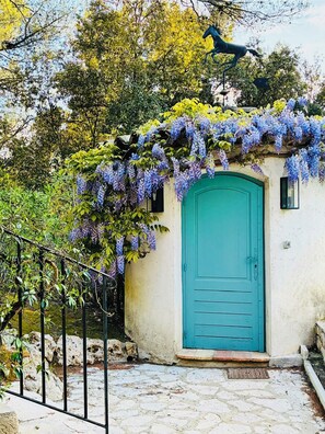 A turquoise door with a small porch, surrounded by greenery and a statue. - Provençal house with swimming pool in a private lane (Roquefort-les-Pins)