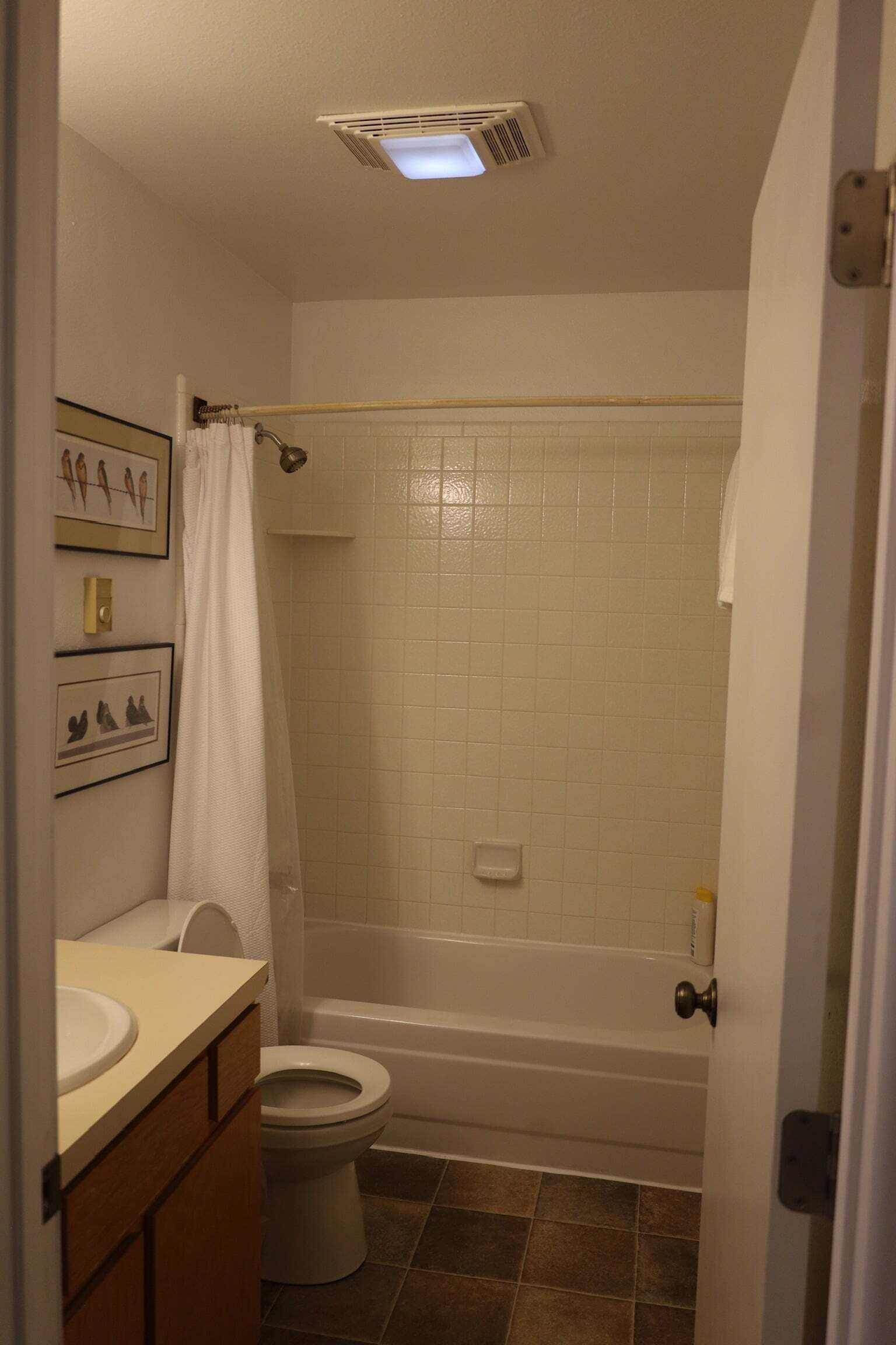 Un baño con inodoro, bañera y cortina de ducha.