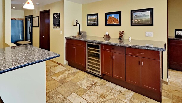 A kitchen with granite countertops, wooden cabinets, a built-in oven, and a tiled floor. - 1849 Condos 309 2 Bedroom Condo (Mammoth Lakes)