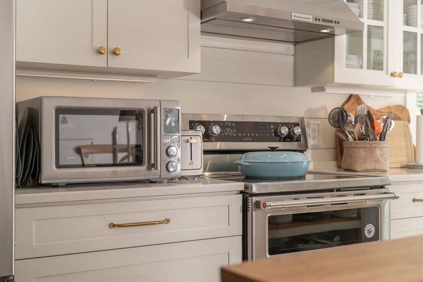 A kitchen with a microwave, toaster, and oven, with cabinets and a countertop.
