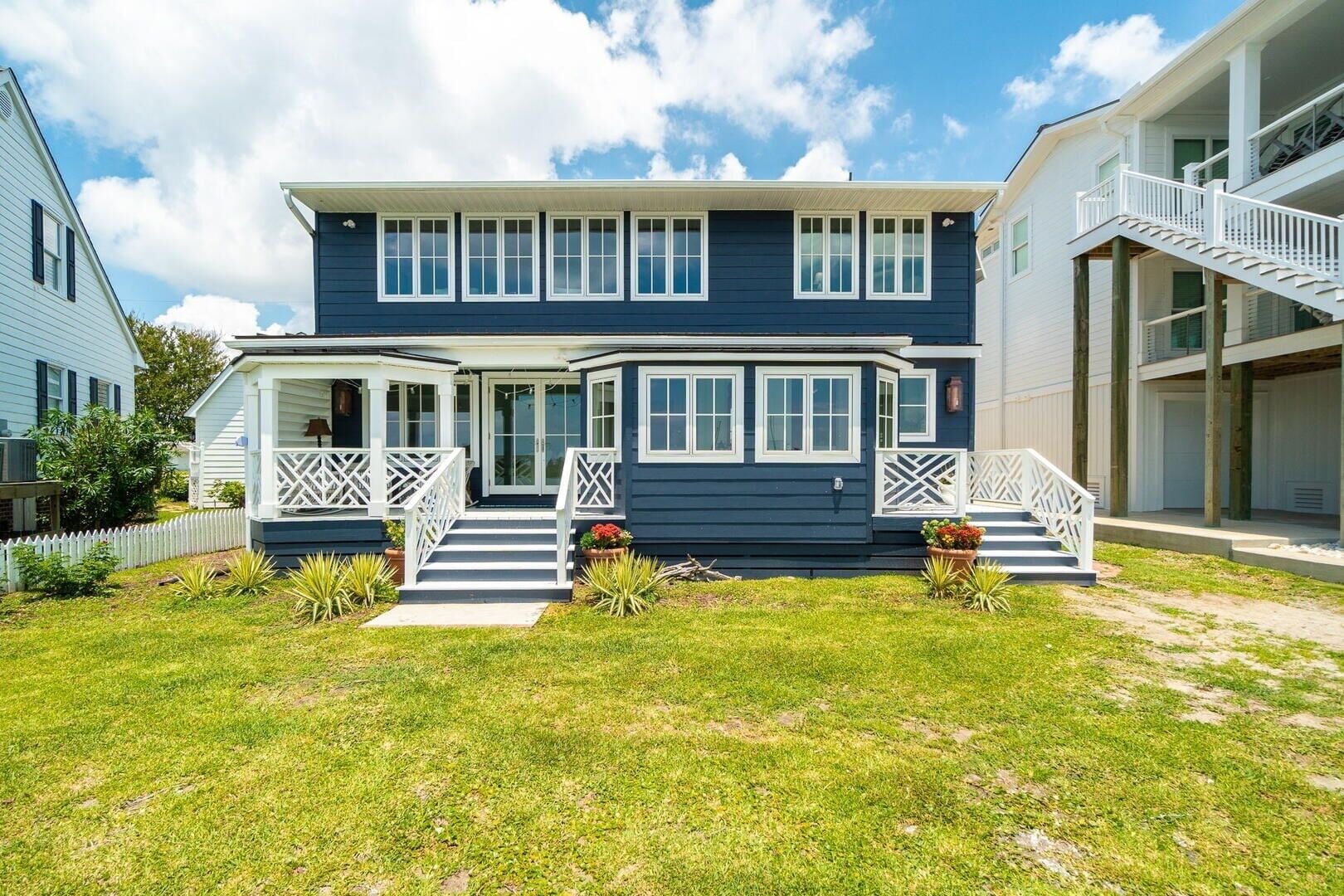 A two-story house with a front porch, a staircase, and a covered area with a railing.