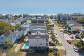 Zona residencial costera con casas, piscina y vista al océano.