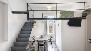 Un interno moderno con una scala, un'area pranzo e un letto a castello.