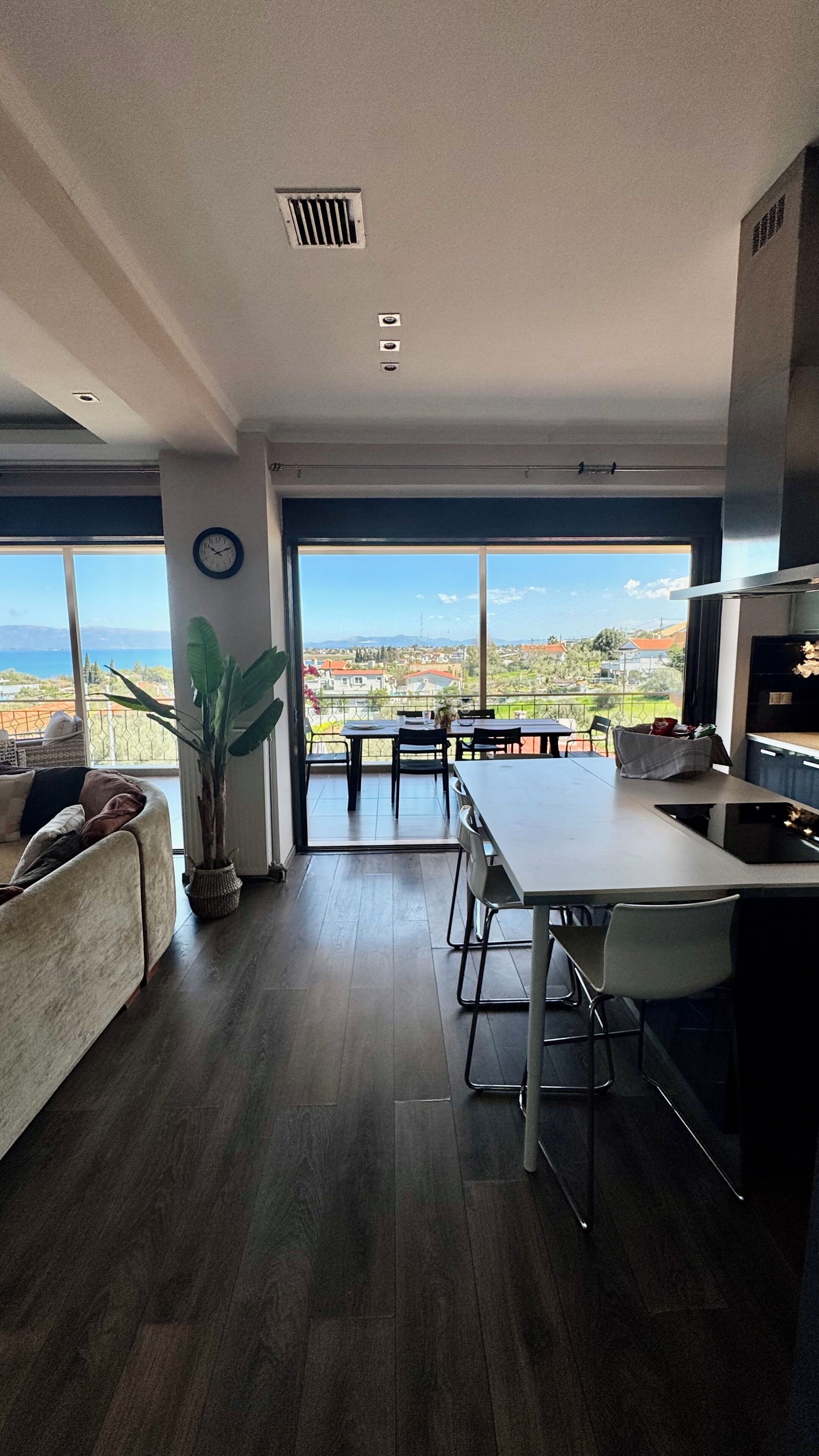 Uma sala de estar moderna com uma janela grande, área de jantar e cozinha.