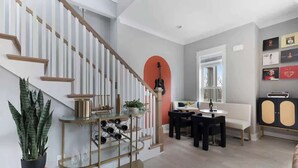 Una sala de estar moderna con una escalera, un comedor y un sofá.