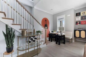 Ein modernes Wohnzimmer mit Treppe, Essbereich und einer Couch.