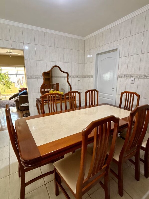 Comedor con una gran mesa rectangular y seis sillas de madera.