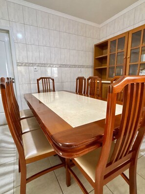 A dining room with a rectangular table and six wooden chairs.