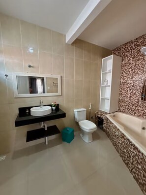 A modern bathroom with a white sink, toilet, and bathtub.