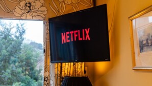 Et fjernsyn ophængt på væggen, der viser Netflix-logoet.