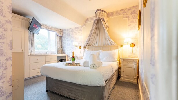 A bedroom with a bed, bedside tables, a TV, a window, and a curtain. - Cransley Room 11 - Apartment close to the beach with communal garden (Bournemouth)