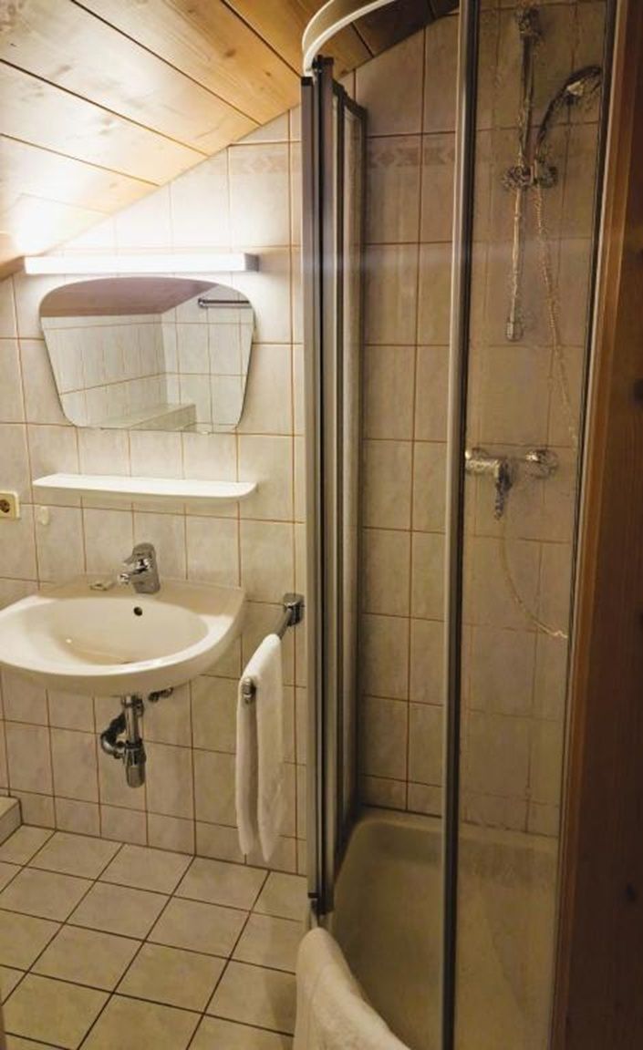 Une salle de bain avec un lavabo, un miroir et une douche.