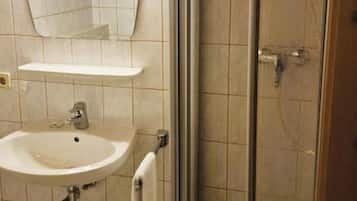 Une salle de bain avec un lavabo, un miroir et une douche.