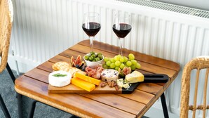 A wooden table with a cheese board, grapes, figs, and two glasses of red wine. - Cransley Room 6 - Close to beaches and town with shared garden (Bournemouth)