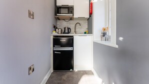 A compact kitchen with a microwave, refrigerator, and sink. - Cransley Room 6 - Close to beaches and town with shared garden (Bournemouth)