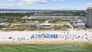 Ein Strandhotel mit mehreren Gebäuden, einem Sandstrand und Blick auf den Ozean.