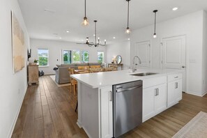 A modern kitchen with a central island, stainless steel appliances, and pendant lighting. - New Listing! Sable Palm| Brand new townhouse in Lost Key| 5 min walk to beach| Two pools| Free Golf (Gulf Beach)