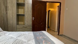 Una camera da letto con un letto, un armadio e una porta che dà su un'altra stanza.