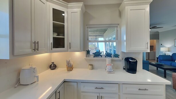 A modern kitchen with white cabinets, a coffee maker, and a toaster on the counter. - Prince Paradise | Spacious, Gulf Views, + Community Pool (Galveston)
