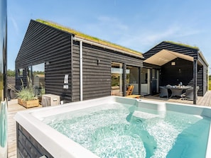 A modern house with a hot tub, wooden deck, and a covered outdoor area. - 4 Star Holiday Home in Saltum (Lokken)