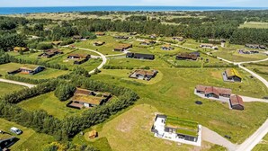 Ett flygbildsbild av ett bostadsområde med hus, vägar och en kustlinje.
