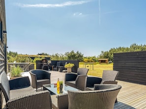 An outdoor patio with wicker furniture, a barbecue grill, and a view of the surrounding area. - 4 Star Holiday Home in Saltum (Lokken)