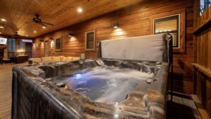 Ein Holzblockhaus-Interieur mit Whirlpool, Holzwänden und Deckenventilator.