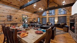 Ein rustikales Holzinterieur mit Essbereich, Sitzgelegenheiten und Kamin.
