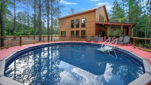 A wooden cabin with a pool, surrounded by trees. - Pretty in Pink: Sleeps 14 (Broken Bow)