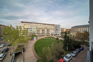 Un immeuble résidentiel à plusieurs étages doté d’une cour intérieure, d’un espace de stationnement et donnant sur la rue.