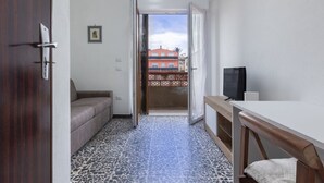 A room with a sofa, a TV, a table, and a patterned floor. - A cozy and spacious 80 square meters apartment, perfect for four people, located on the first floor of a typical Sant'Antioco building (NO elevator).The property is located a short distance from the town center and offers quick access to the seafront. It (Sant'Antioco)