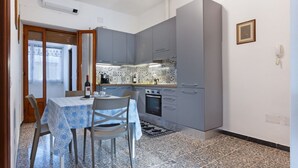 A compact kitchen with grey cabinets, a dining table with chairs, and a patterned backsplash. - A cozy and spacious 80 square meters apartment, perfect for four people, located on the first floor of a typical Sant'Antioco building (NO elevator).The property is located a short distance from the town center and offers quick access to the seafront. It (Sant'Antioco)