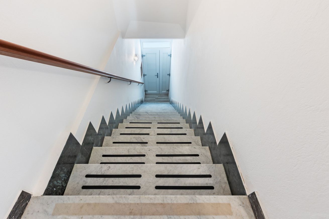 Eine Treppe mit Handlauf, die zu einer Tür führt.