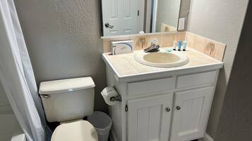 A bathroom with a toilet, sink, and cabinet.