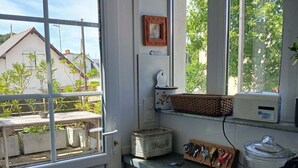 Une cuisine avec une fenêtre, un réfrigérateur, un évier et un plan de travail sur lequel se trouvent divers objets.